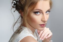 Pretty bride with beautiful elegant hairstyle, isolated on a gray background.