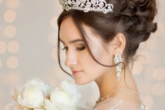 Wedding Hairstyle in a short dress with lace in the crown earrings. Wedding bouquet